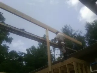 Carpenter setting a ridge beam over a new addition frame — Ice Dam Removal by Roofing Brothers in Lewisville