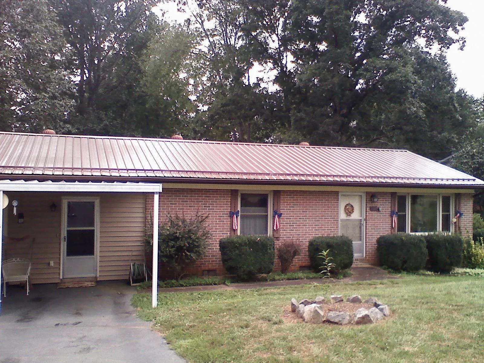 Bronze metal roof and carport on a brick ranch home — Roof Repair work by our crew in Lewisville